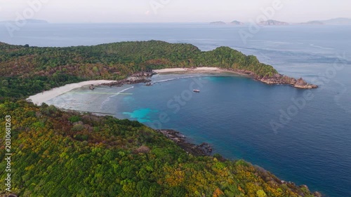 Aerial view of a tropical paradise beach island with green forest eco system and crystal clear turquoise water and white sand beach background	