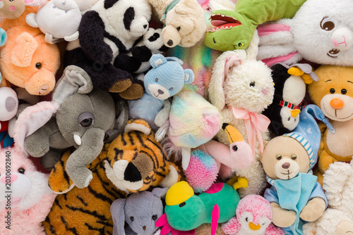 Heap of colorful soft animal toys background. Different messy baby goods. Closeup. Flat lay. Top down view.