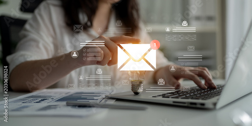 Cuadro en lienzo A woman in a white shirt engages with a digital email notification on her laptop, symbolizing modern communication and productivity in a contemporary office setting