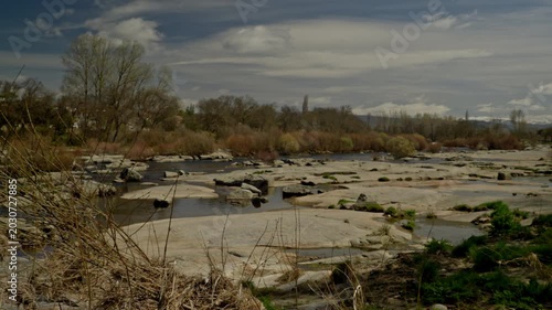 Riverbed with low water exposing large flat rocks and puddles
