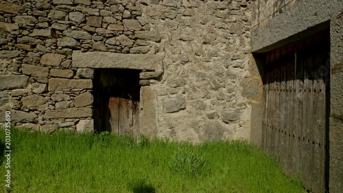 Weathered stone wall supporting two rustic wooden doors