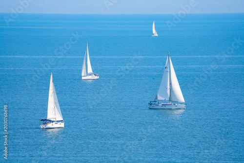 White sailboats on the blue sea	