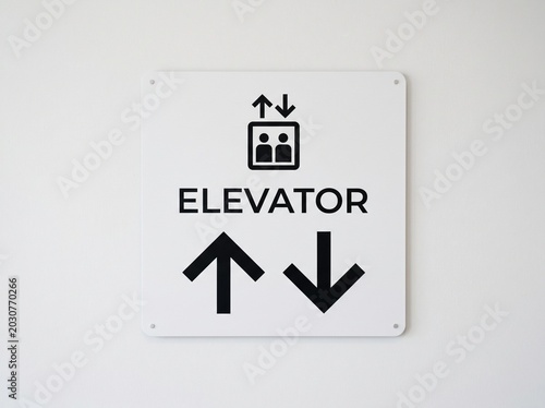 Elevator sign with lift symbol and directional arrows on white background, suitable for malls, offices, hotels, and public building signage.