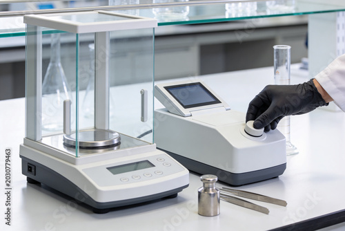 Precision laboratory scales and scientific equipment on a clean white table