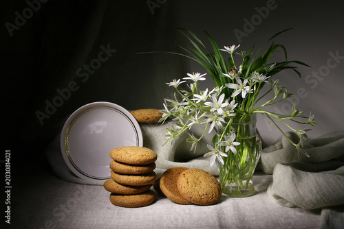 Photos Still life with oatmeal cookies and a bouquet of white flowers in a vase