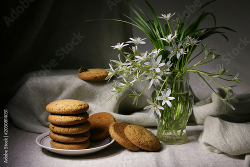 Tableau sur toile Still life with oatmeal cookies and a bouquet of white flowers in a vase