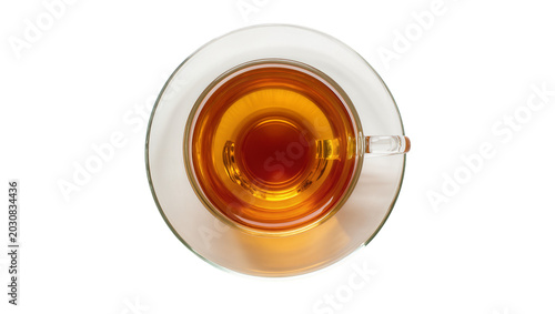 Obraz na plátně Glass cup of amber tea on saucer, top view