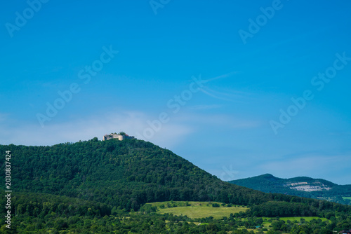 Germany, Panoramic Swabian Jura mountain landscape with Hohenneuffen castle ruins rising above forests near Beuren village