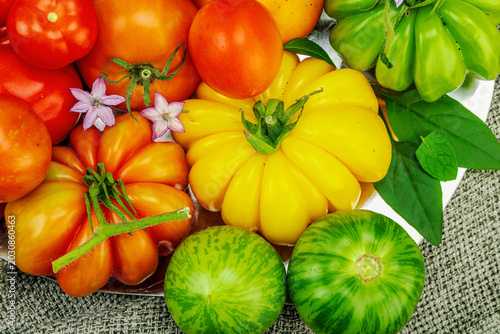 фотографія Assorted homegrown heirloom tomatoes of various shapes, sizes and colors with sm