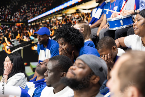 Vászonkép Disappointed soccer supporters reacting to missed chance during tense football match, filled with hope and tension in the stadium stands