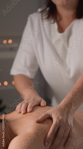 A skilled massage therapist performs a relaxing back massage in a peaceful spa environment with soft candlelight. The serene setting promotes stress relief, wellness, and rejuvenation for clients