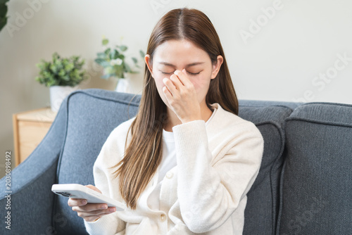 Bild auf Leinwand Presbyopia, Hyperopia middle aged asian woman hand rubbing her eye with vision blurred ,girl trying to read text message from smart mobile phone screen, eye disease of old, eyesight farsightedness