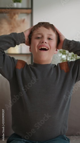 Young boy expresses extreme distress and frustration by screaming with hands on head indoors