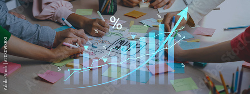 Fotografie A dynamic business meeting scene showcasing diverse hands collaborating on data analysis and strategy planning, emphasizing teamwork and innovation in a modern workspace