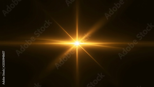 Golden lens flare light effect with starburst rays on black background