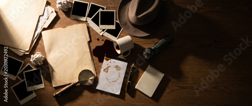 Detective desk with photos and evidence on wood table