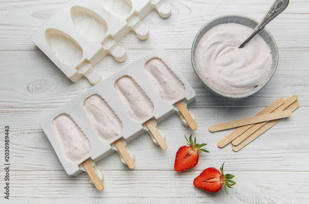 Obraz premium Preparing homemade strawberry popsicles in silicone molds