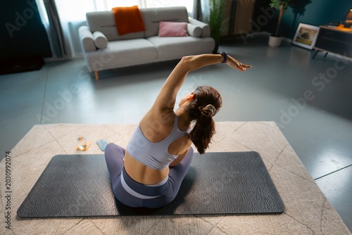 Φωτογραφία A person is doing stretching exercises on a mat in the living room
