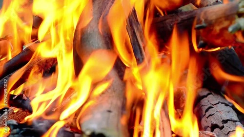 4K cinematic full screen background of intense orange fire flames burning. Bright glowing campfire loops texture with heat distortion and crackling sound. Static shot.