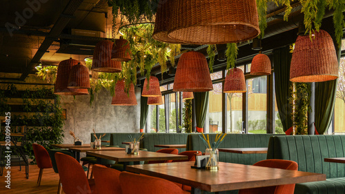 Canvas Print Modern restaurant interior with hanging rattan lamps and lush greenery