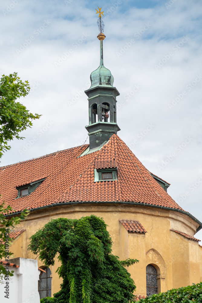 Fototapeta premium Historic church roof and patina bell tower under cloudy sky