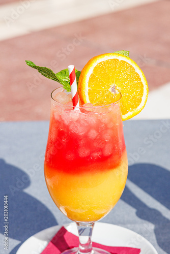 Cold, colorful alcoholic drink on a restaurant table during a sunny vacation