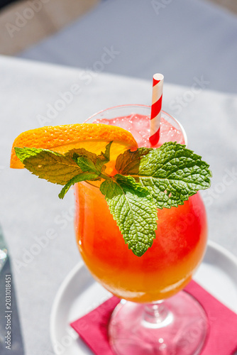 Cold, colorful alcoholic drink on a restaurant table during a sunny vacation