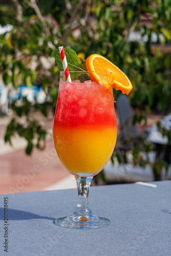Vibrant summer mocktail with crushed ice served at a beach bar resort