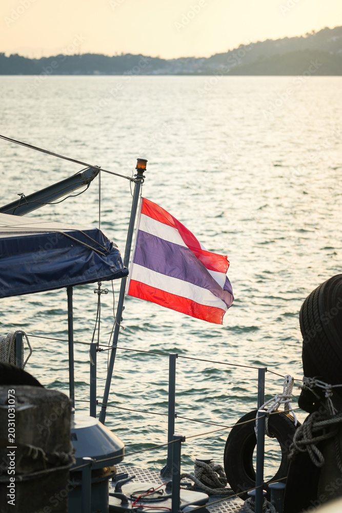 Obraz premium The tricolor flag of Thailand on a vessel, representing Southeast Asian maritime travel, tropical tourism destinations, and patriotic identity.