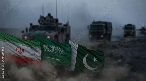 Flags of Iran, Saudi Arabia and Pakistan waving in foreground with military vehicles. Concept of geopolitical rivalry, oil politics, economic sanctions, resource control, Middle East conflict