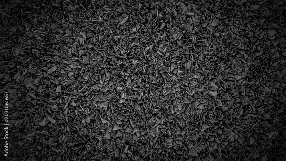 Fototapeta premium Texture of crumpled black paper fills the space with a detailed pattern of folds and creases under soft lighting