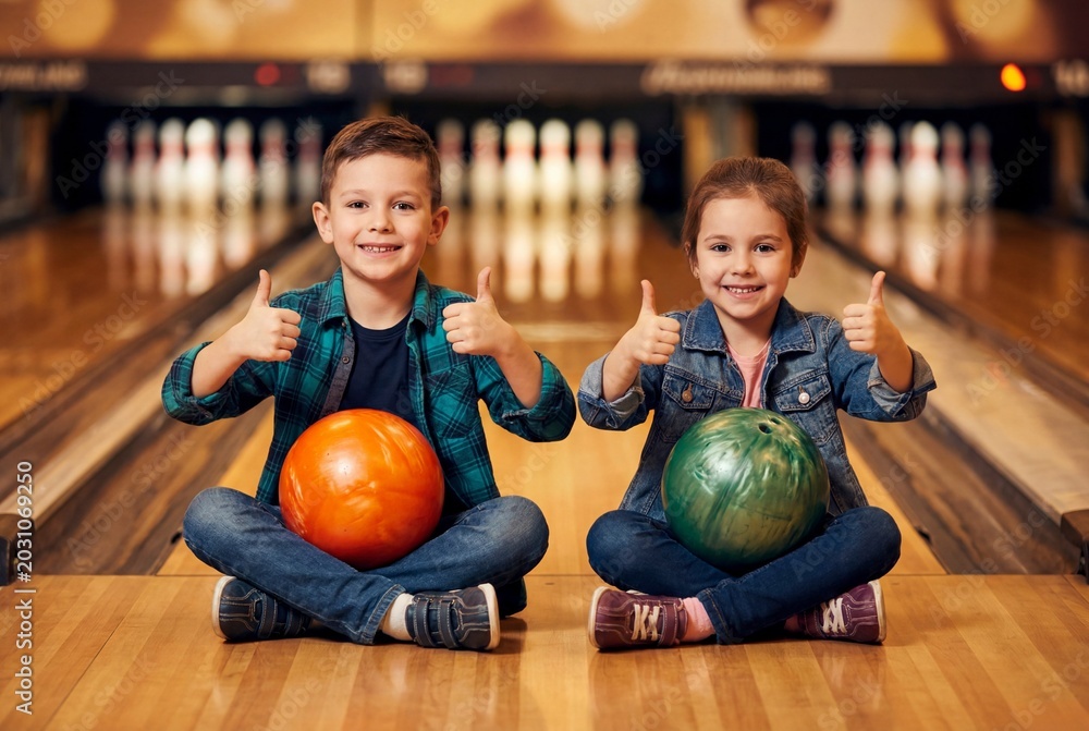 Fototapeta premium Happy Kids Celebrating Victory at the Bowling Alley with Thumbs Up