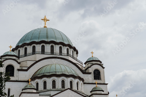 Large domes of Saint Sava Temple rise under dramatic clouds in Belgrade Serbia. Concept of religion, heritage, spirituality and architecture