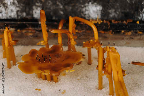 Принти на полотні Melted wax and bent candles rest inside a prayer stand