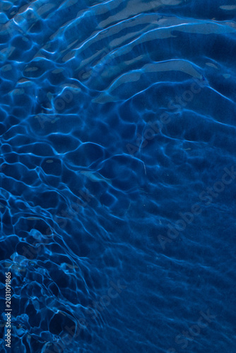 Dark deep blue water ripples background. The ocean colorful summer inspiration.