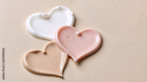 Three cosmetic heart shapes on a neutral background