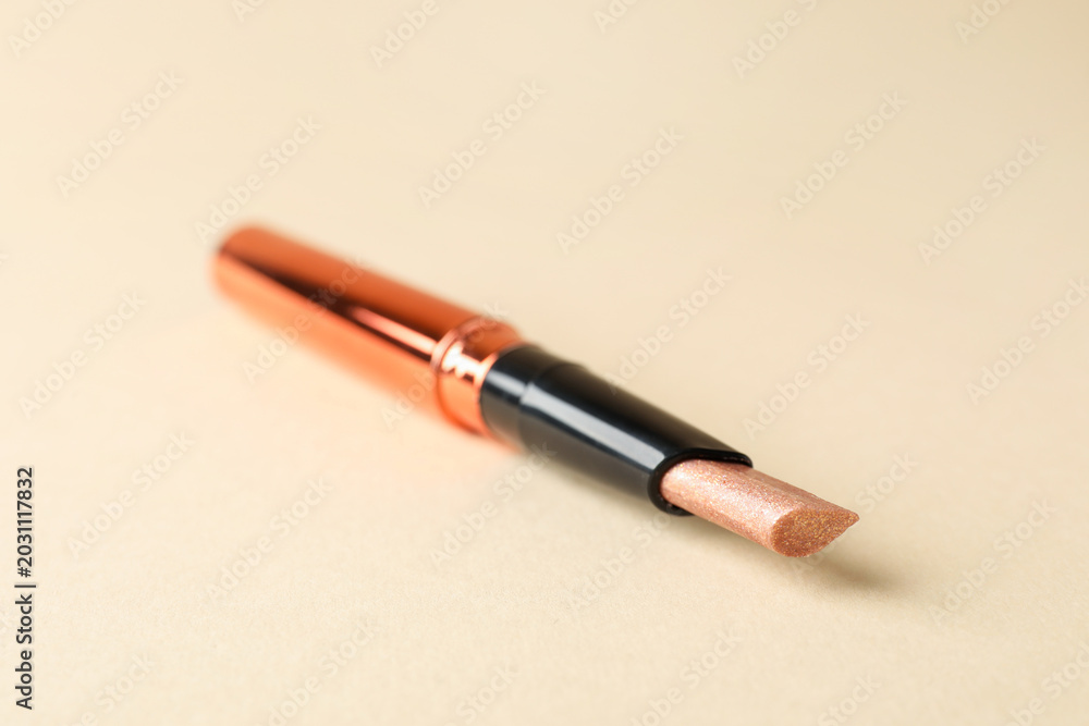 Fototapeta premium Highlighter stick on beige background, closeup. Space for text