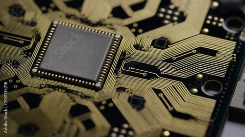 Microchip circuit board macro technology shot with gold traces, pins, and detailed electronic components