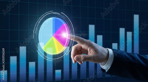 Businessman interacts with colorful pie chart on digital screen with bar graph background