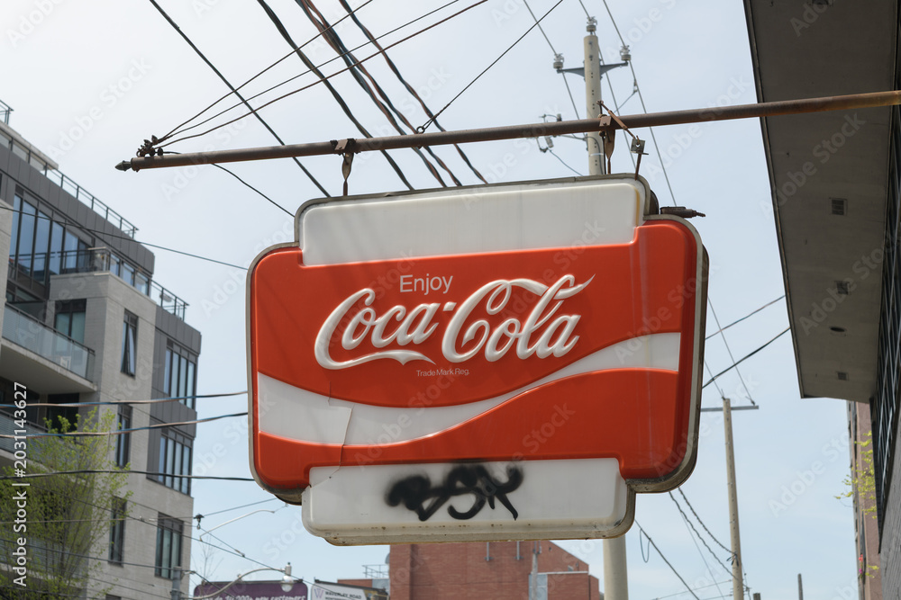 Naklejka premium wall mounted projecting vintage Enjoy Coca-Cola sign, close-up in Toronto (ghost sign outside Cebon Variety, 672 Kingston Rd)