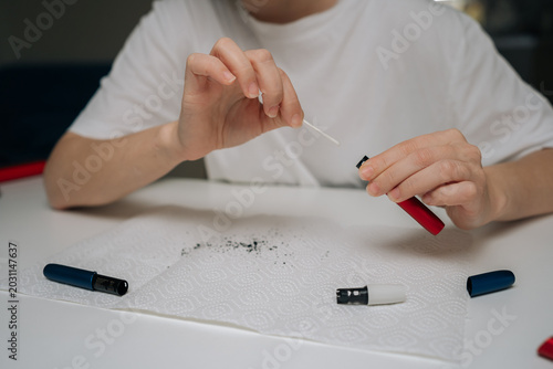 Foto Cropped shot of person cleaning electronic cigarette mouthpiece with cotton swab, removing residue for hygiene and maintenance in focused, close-up domestic self-care routine