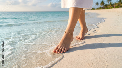 Woman with anklet bracelet walking on tropical white sand beach with ocean wave