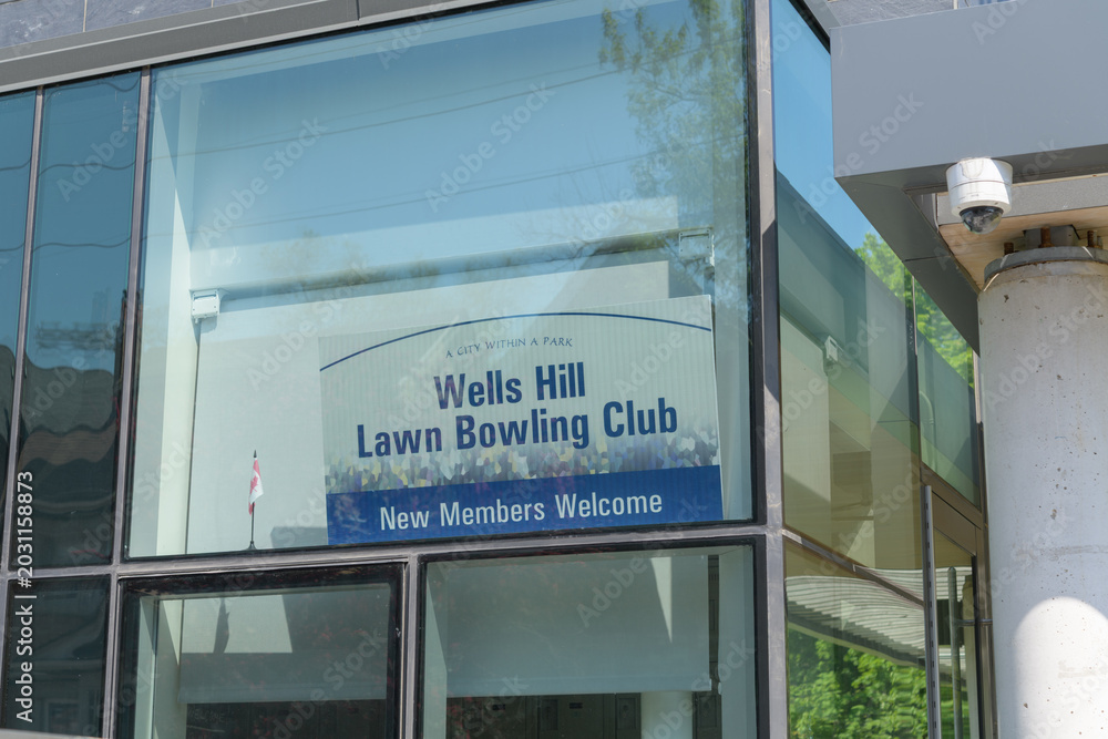 Naklejka premium Wells Hill Lawn Bowling Club sign inside window of Toronto Public Library - Wychwood Branch - 46 Melgund Rd