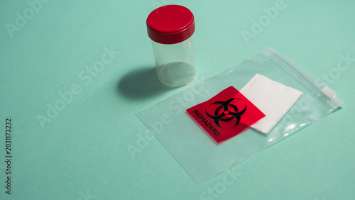 Bild auf Leinwand Specimen Container with Biohazard Bag on Teal Background — Medical Sample Collec