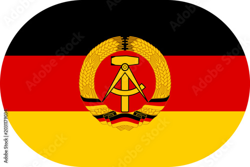 East Germany flag. Former state flag of the German Democratic Republic featuring black, red and gold stripes with the national emblem. Vector flag in flat oval design