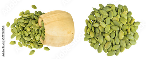 Peeled pumpkin seeds in wooden bowl isolated on white background. Top view. Flat lay