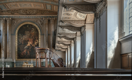 Bild auf Leinwand From a low perspective across rows of dark wooden pews, the breathtaking altar of the Chapel of St Peter & St Paul unfolds in classical majesty