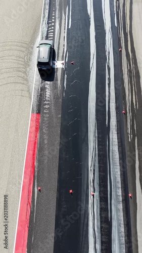 Vertical Aerial Top Down View of Car Driving on Race Circuit Tarmac