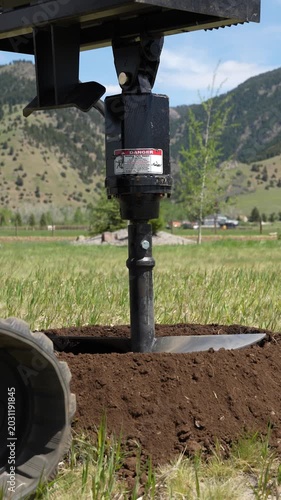 Hydraulic earth auger drilling a hole into the ground for a house foundation 4k