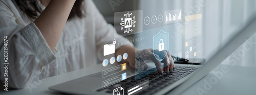 Quadro su tela A woman interacts with a laptop showcasing a digital interface with data analysis and cybersecurity visuals, emphasizing technology in a professional environment